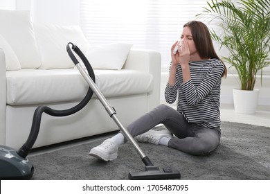 Young Woman Suffering From Dust Allergy While Vacuuming House