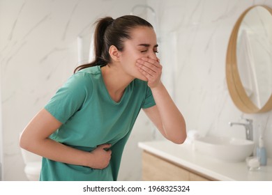Young woman suffering from nausea in bathroom. Food poisoning