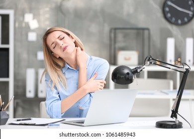 Young Woman Suffering From Neck Pain In Office