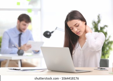 Young Woman Suffering From Neck Pain In Office