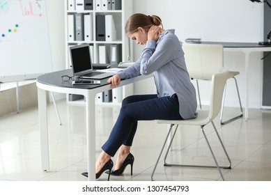 Young Woman Suffering From Neck Pain In Office