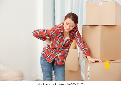 Young Woman Suffering From Pain After Moving Heavy Box