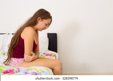 young woman suffering from period pains - Shutterstock ID 328398779