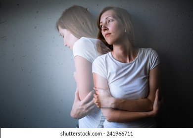 Young woman suffering from a severe depression/anxiety (color toned image; double exposure technique is used to convey the mood of unease, progression of the anxiety/depression)