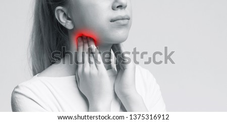 Young woman suffering from tonsillitis, pulping her neck, monochrome panorama photo, free space