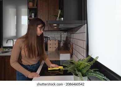 Young Woman Suffers From Depression After A Breakup Or Divorce And From Obsessive Compulsive Disorder OCD Cleans Kitchen Cook Top To Calm Her Nerves. Serious Stressed Female Rubbing The Home