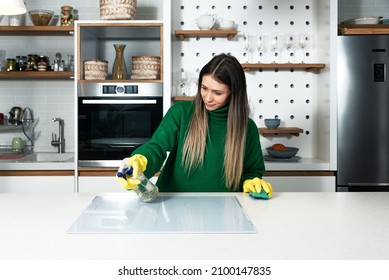 Young Woman Suffers From Depression After A Breakup Or Divorce And From Obsessive Compulsive Disorder OCD Cleans Kitchen Cook Top To Calm Her Nerves. Serious Stressed Female Rubbing The Home