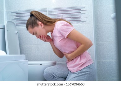 Young woman suffers from nausea and vomiting due to digestive and stomach problems. Morning toxicosis in early pregnancy. Food infection poisoning 