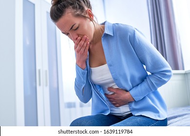 Young Woman Suffers From Nausea And Vomiting Due To Digestive And Stomach Illness Problems And Gastrointestinal System Diseases Or Food Poisoning. Morning Toxicosis In First Trimester Of Pregnancy