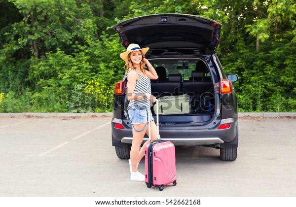 Young woman with suitcases. Vacation concept. Car\
trip. Summer travel.