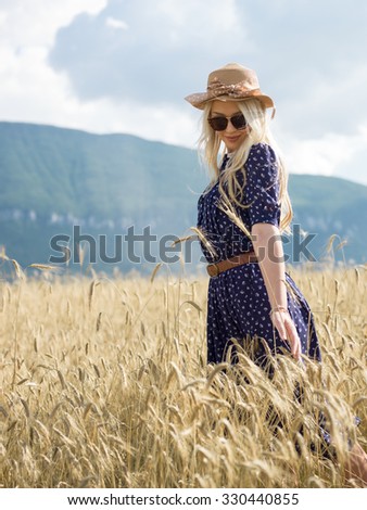 Young woman in summer dress walking in the field