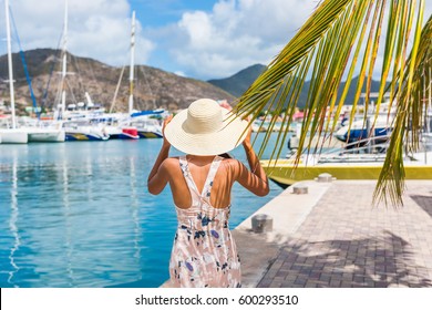 Young woman with sun hat in Philipsburg marina harbor, St Maarten, popular port of call for cruise ship travel destination. Netherlands Antilles, tropical summer vacation.