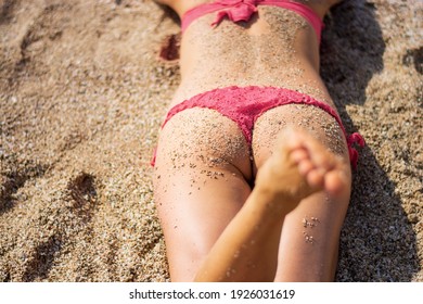 Young Woman Sunbathes In Bikini On The Beach