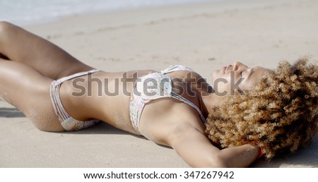 Young woman sunbathing in bikini alone on the summer beach