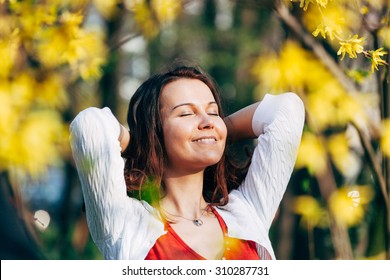 Young Woman Sunbathing In The Park