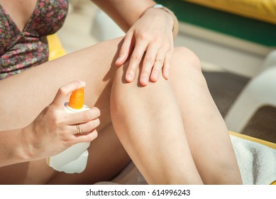 Young Woman Sunbathing At The See And Applying Sun Protector