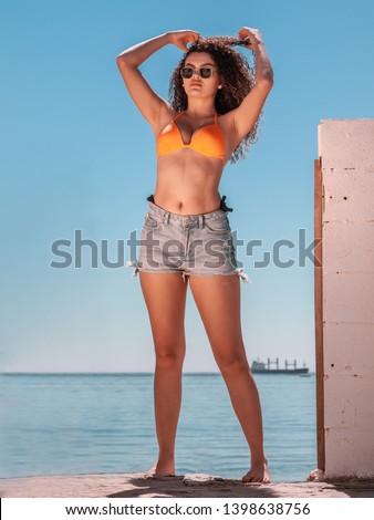 Similar – Brunette surfer woman with top and bikini holding surfboard