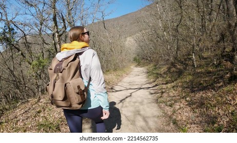 A Young Woman In Sunglasses With A Large Backpack Walks In The Forest And Looks At The Trees. Hike To Nature. 4K UHD