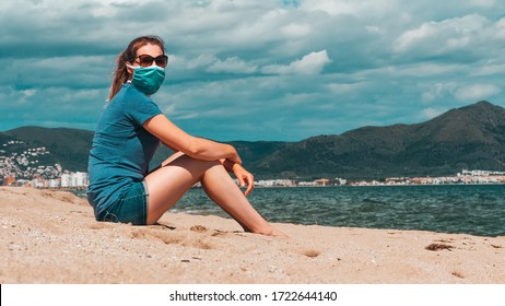 Young woman in sunglasses and medical mask sitting alone at the beach, new normal concept. Life after coronavirus pandemic, travel and vacations at sea with new rules theme - Powered by Shutterstock