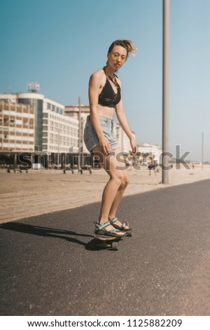 Similar – Young man riding on skate and holding surfboard