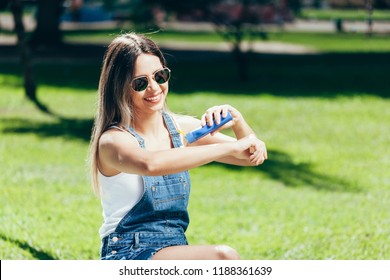 Young woman with sunscreen and sunglasses outside on a beautiful summer day - Powered by Shutterstock