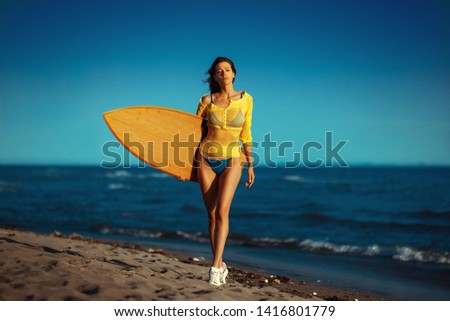 Similar – Young surfer woman with top and bikini holding surfboard