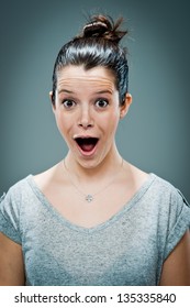 Young Woman with Surprise Expression over a Grey Background