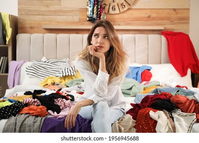 Young Woman Surrounded By Different Clothes In Messy Room. Fast Fashion Concept