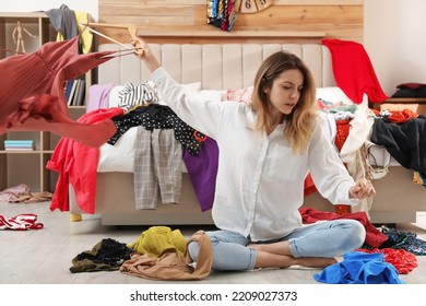 Young Woman Surrounded By Different Clothes In Messy Room. Fast Fashion Concept