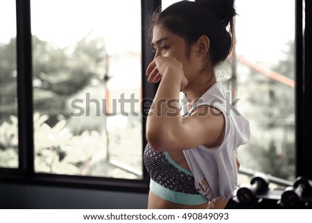 Young woman sweating after a session of training in fitness room.