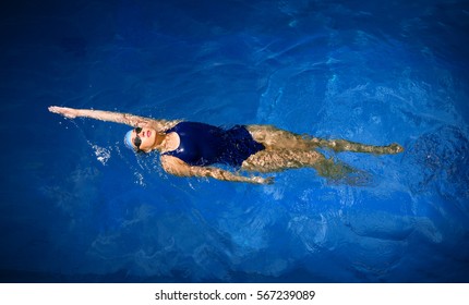 Young woman swimmer in blue pool water - Powered by Shutterstock