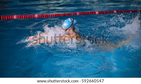 Young woman swimmer in blue pool
