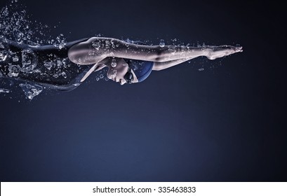 Young woman swimmer in cap and glasses under water