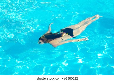 Young Woman Swimming Underwater In The Swimming Pool