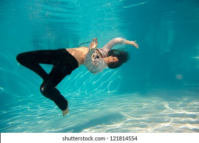 Young woman swimming undewater in the swimming pool - Powered by Shutterstock