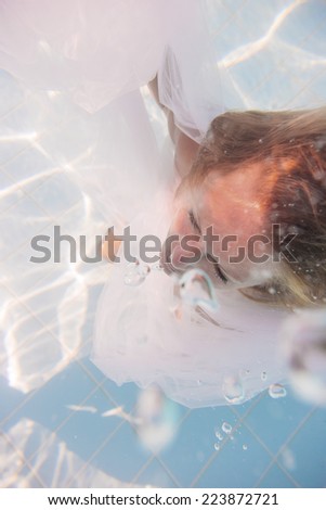 Woman face lying down over hands with colorful sparkles in skin