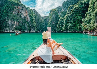 Young woman in swimsuit enjoying on traditional long-tail Boat over beautiful mountain and ocean, Phi phi Islands, Thailand