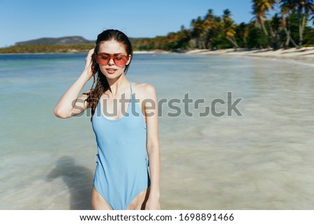 young woman in a swimsuit on the beach with her hair