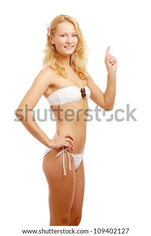 A young woman in a swimsuit showing something, isolated on white background