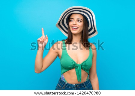 Young woman in swimsuit in summer holidays intending to realizes the solution while lifting a finger up