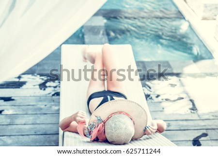 Woman applying sunscreen by the pool during summer