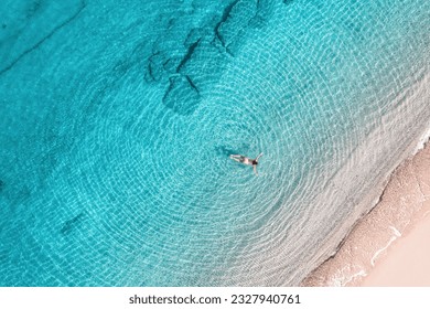 Young woman in a swimsuit swimming in sea water on the beach. View from above. Top, drone view - Powered by Shutterstock