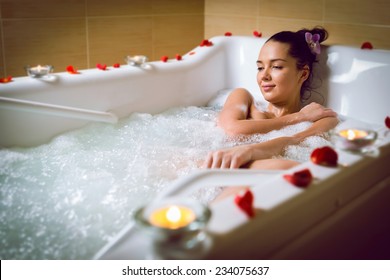 Young Woman Take Bubble Bath With Candle. 