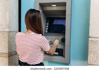 A young woman takes money from an ATM. Finance, credit card, withdrawal of money. Life style. Grabs a card from the ATM.