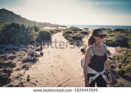 young woman takes a walk in the wilderness along a coastal path