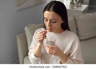 Young Woman Taking Abortion Pill At Home