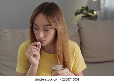 Young Woman Taking Abortion Pill At Home