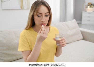 Young Woman Taking Abortion Pill At Home