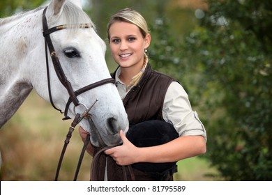 young woman taking care of her horse