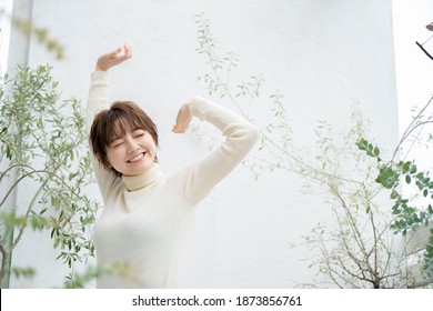 Young Woman Taking A Deep Breath On The Veranda